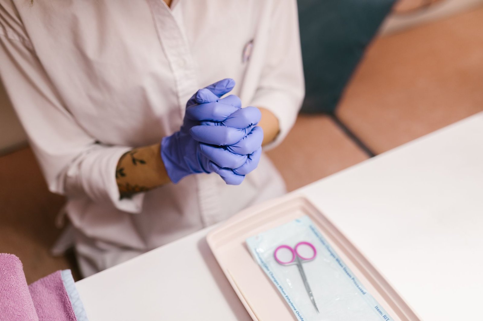 Nail technician wearing gloves preparing for a manicure session in a salon setting.